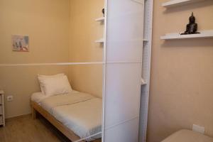 een kleine kamer met een klein bed en planken bij Precioso apartamento en Los Cristianos in Los Cristianos