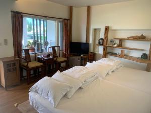 1 dormitorio con 3 almohadas blancas en una cama en Two Dots On Line Homestay en Hualien
