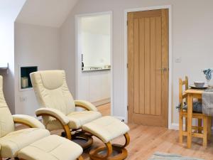 a living room with two chairs and a table at Leveret Lodge in Leavenheath