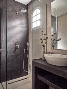 a bathroom with a glass shower and a sink at Tropical Studios in Laganas