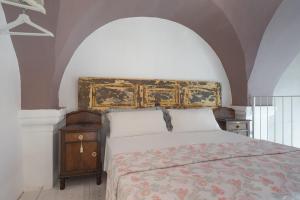 アレーツィオにあるDimora Petrachi 1890のベッドルーム1室(華やかなヘッドボード付きのベッド1台付)