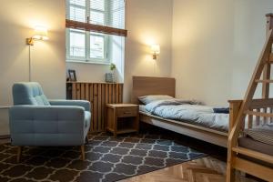 - une chambre avec un lit et une chaise bleue dans l'établissement Cactus apartment FREE parking for a standard car, à Ljubljana