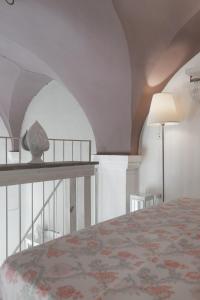 アレーツィオにあるDimora Petrachi 1890のベッドルーム1室(ベッド1台、ランプ、天井付)