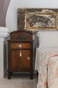 アレーツィオにあるDimora Petrachi 1890のベッドルーム1室(ベッドの横に木製ドレッサー付)
