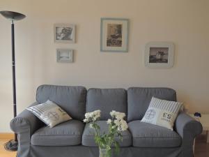 a gray couch with flowers in a living room at Castillo 27 by Clabao in Pamplona