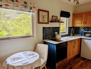 a kitchen with a table and a sink and a window at The Pack Horse Exmoor National Park Allerford Riverside Cottage & Apartments in Minehead