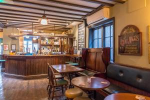 a restaurant with wooden tables and a bar at The Station Inn Whitby in Whitby