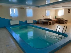 een groot zwembad in een kamer met een woonkamer bij Готель МАГНАТ 