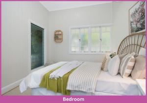 a bedroom with a bed with white walls and a window at Harold Street 139 in Townsville