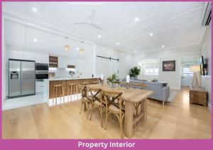 a kitchen and living room with a wooden table and chairs at Harold Street 139 in Townsville