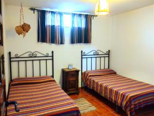 1 dormitorio con 2 camas y ventana en La Casita de Piedra, en Ronda