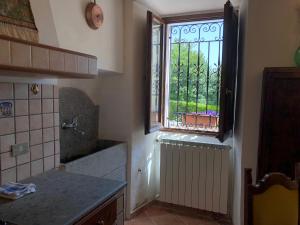 eine Küche mit einem Fenster, einem Waschbecken und einer Theke in der Unterkunft Maison Fonticella, HOST APARTMENTS in Rivisondoli