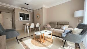 een woonkamer met een bank, stoelen en een tafel bij Penthouse Casa Baja las Palmeras - Roda Golf in San Javier