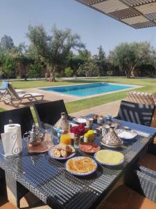 a table with food on it next to a pool at vacances luxe in Marrakesh