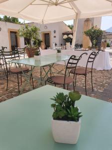 a table and chairs in a patio with an umbrella at Hotel Villa Lampedusa in Palermo