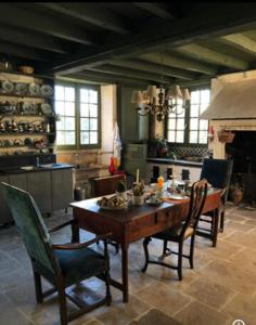 a dining room with a table and chairs and a fireplace at Chambres d'Hôtes Le Clos de Bonneval in Saint-Jean-de-Thouars