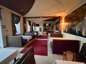 un ristorante con tavoli, sedie e un tappeto rosso di Готель МАГНАТ 