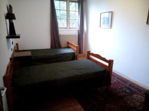 1 dormitorio con 2 camas y ventana en La maison de la Guérande, en Hénanbihen