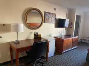 Habitación de hotel con escritorio y espejo en Econo Lodge, en Kalamazoo