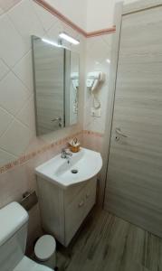 a bathroom with a sink and a toilet and a mirror at Ciccina Rooms in Marzamemi