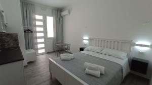 瑪爾薩梅米的住宿－Ciccina Rooms，一间卧室配有一张大床和两条毛巾