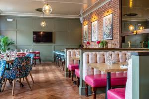 een restaurant met tafels en stoelen en een bar bij The Crown Inn in Bromley