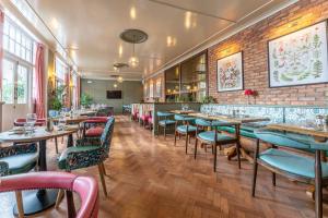 a restaurant with tables and chairs and a brick wall at The Crown Inn in Bromley