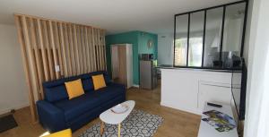 a living room with a blue couch and a kitchen at Studio Zen in Niort