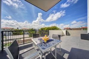 a patio with a table and chairs on a balcony at Moderno Residences By Bay Breeze in Miami Beach