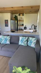 a living room with a couch and a kitchen at Konini Retreat in Rarotonga