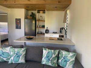 a living room with a couch and a kitchen at Konini Retreat in Rarotonga