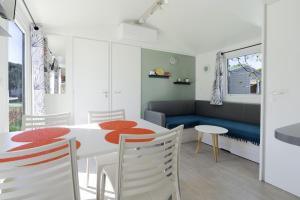 a kitchen and dining room with a table and chairs at Mobile-home 132 in Lattes