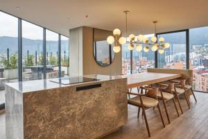 a kitchen with a large table and chairs and glass windows at ICON 100 Luxury Apartasuites in Bogotá