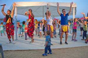 a group of people dancing on the beach with a child at Hermes Club Hotel - Ultra All Inclusive in Tsarevo +78 photos