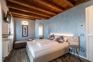 烏迪內的住宿－Atmosfere Charme & Country，一间卧室设有一张大床和蓝色的墙壁