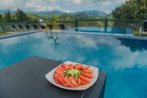 a plate of carrots on a table next to a pool at Ravana Range Ella in Ella