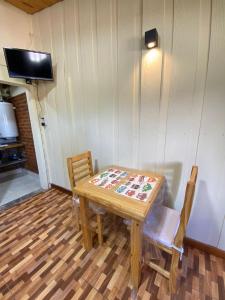 a table and chairs in a room with a television at Departamentos Fortin in Trevelin