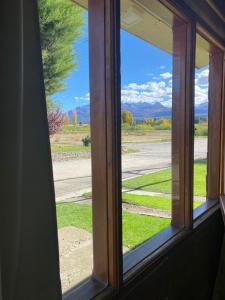 a window with a view of a field and a road at Departamentos Fortin in Trevelin