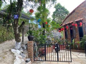 a gate in front of a house with a tree at Sunshine villa thuy bieu in Hue
