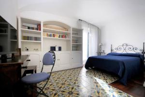 a bedroom with a bed and a desk and chairs at Antico Convento Sorrento in Sant'Agnello