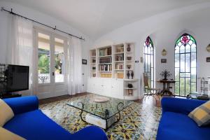 a living room with a blue couch and stained glass windows at Antico Convento Sorrento in Sant'Agnello