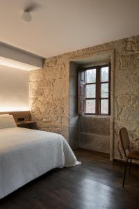Schlafzimmer mit einem Bett und einem Fenster in der Unterkunft Pazo da Buzaca in Moraña