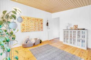 uma sala de estar com paredes brancas e um tecto de madeira em Blmunkevangen 21, 3120 Dronningmlle em Dronningmølle