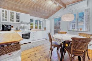 - une cuisine avec une table et des chaises dans la chambre dans l'établissement Blmunkevangen 21, 3120 Dronningmlle, à Dronningmølle
