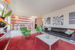 韋爾巴尼亞的住宿－La Terrazza sul Lago，客厅配有沙发、桌子和绿色椅子