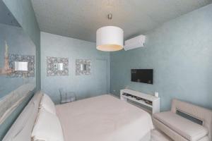 a bedroom with a white bed and a tv at La Terrazza sul Lago in Verbania