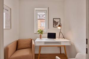 escritorio con ordenador portátil y silla en la habitación en Bella, Stil des Expressionismus en Kaiserslautern