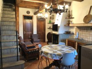 ein Wohnzimmer mit einem Tisch, Stühlen und einer Treppe in der Unterkunft Maison Fonticella, HOST APARTMENTS in Rivisondoli