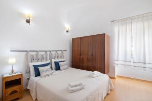 ein Schlafzimmer mit einem großen weißen Bett mit Handtüchern darauf in der Unterkunft Bela Vista Retreat - Lavender in Olhão