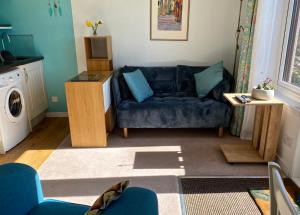 a living room with a blue couch and a washing machine at Little Haven in Gairloch